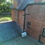 Discreet outdoor air conditioning unit sited on flat roof of period home