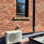 Black external trunking blended into period brickwork to hide refrigerant pipework